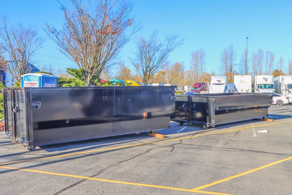 Professional dumpster rental service with roll-off container on residential driveway in Greece